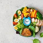 A bowl of vegetable meat with meat, fish, eggs, and a clock at the middle.