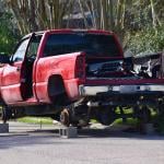 A stolen red pick-up truck in Texas, stripped and hoisted with bricks.