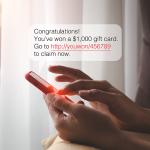 SMS chat bubble displaying a cash prize message over a person typing on a smartphone.