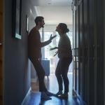 A couple fighting in a hallway of their apartment.