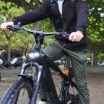 Man riding electric bicycle on a street.