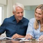 A middle-aged couple reviewing documents at home.