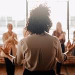 A woman in front of her colleagues leading a talk in the workplace.
