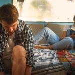 A young couple living inside a renovated, stylish old bus.