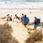 Tourists climb down the Torrey Pines cliffs heading towards Black's Beach in La Jolla in San Diego, California.