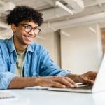 A young freelancer using a laptop to work remotely.