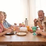 A happy family including grandparents seated in a table during breakfast.
