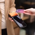 Person taps a business credit card on a payment terminal.