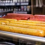 Hot dogs on a roller grill in a gas station.