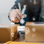 A logistics worker fulfills boxes of orders illustrated with a modern delivery system software graphics.