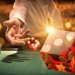 Man throws die at a casino table.