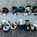Top view of a large business group around a table during a meeting.