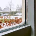 Double-glazed windows with accumulated snow on its edges.