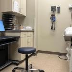 An empty examination room in a clinic with a computer, exam tamble, stool and various medical devices on the wall in Muscle Shoals, Alabama USA.