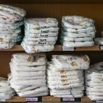 A daycare center's shelf with stacks of various children's diapers with their names written on them.