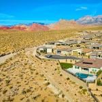 An aerial view of a modern suburban residential neighborhood situated in a mountainous desert area.
