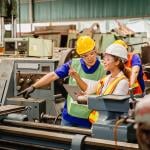 Heavy industry machine workers coordinating on site.