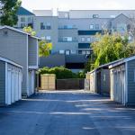 Symmetrical view of urban apartments' garages in a paved driveway.
