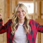 Jasmine Roth poses for a portrait inside a home renovation, wearing red and black buffalo check plaid. 