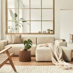 Interior of a modern living room with a modular sofa, decorated with beige and wooden motifs.