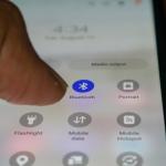 Close up view on a person's finger tapping on the bluetooth app on a phone.