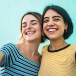 Two young women smiling for a selfie-style photograph.