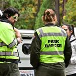 Three park rangers behind their car on duty at Curry Village in the Yosemite Valley at Yosemite National Park, California.