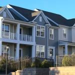 A row of townhouses with grey and white exterior in a housing community.