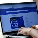 Hands typing on a laptop displaying a Black Friday Deals advertisement page.