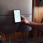 A homeowner using a phone monitoring a battery from Sunrun, a company which provides home solar and batteries. A new partnership between Sunrun, Ford and the Baltimore Gas and Electric Company has resulted in a residential vehicle to grid pilot project.