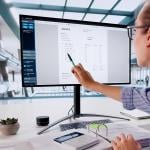 Person pointing out line item on invoice on large computer monitor.