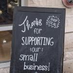 Small business chalkboard sign on sidewalk saying "Thanks for supporting our small business."