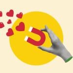 A custom illustration of a hand holding a magnet pulling hearts.