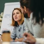 A young businesswoman in a meeting with her colleagues in a boardroom.