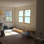 Paint samples on a wall of a sun-lit room with remodeling in progress.