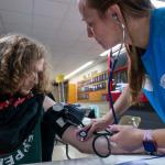 A high school student getting his blood pressure checked at a mobile medical clinic in Terre Haute South High School, Indiana.
