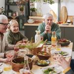 A group of senior people talking to each other at the dinner table.