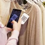 A woman scanning a clothing item's QR code on her phone.