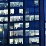 Glass facade of a modern corporate building during night.