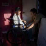 Maria Patricia Alcantara (R), wheels Jose Epifanio Sanchez Trujeque (L) to the bathroom at their home in Lebec, California.