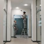 Two installation workers setting up a surveillance camera.