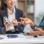 A car loan agent showing a client a sample computation.