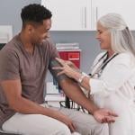 A physician checking her patient's blood pressure.