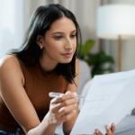 Woman checking bills in the living room.
