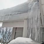 Thick ice dam formed on a house's roof.