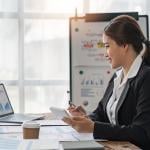 A business woman reviewing finance reports at work.