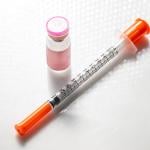 A vial with injectable compound and a syringe.