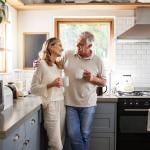 A middle-aged couple having a coffee in their kitchen.