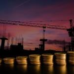 A row of stacked coins with an estate construction site background.