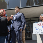 Andreina Mejia, mother of the Arleta High School student, a citizen, who was detained by immigration agents, speaks about their experience at a press conference announcing legal claims against the U.S. government. A few people stand beside her, including one woman holding a sign that reads, "No ICE in our schools."